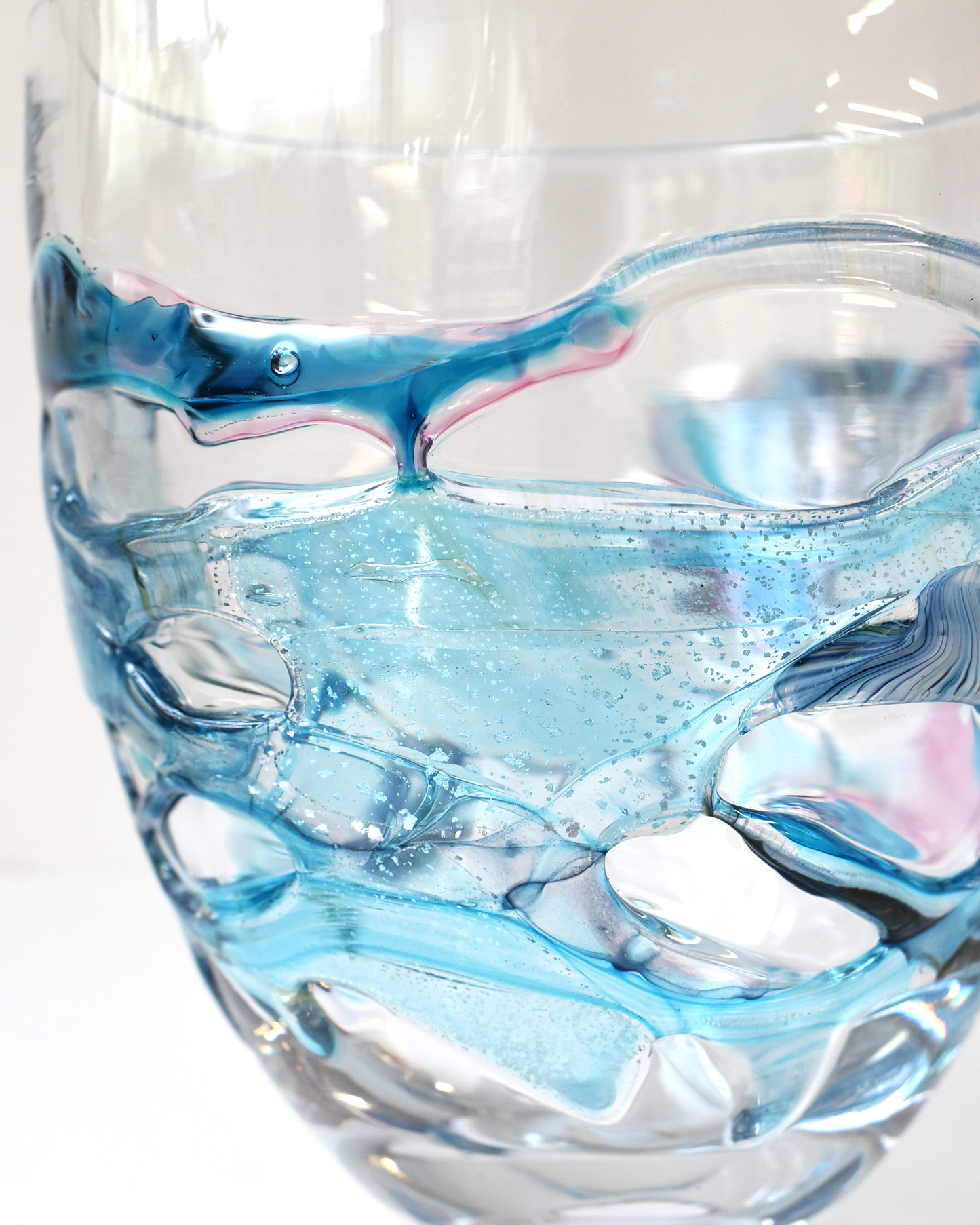 Glass vase with blue and white marbled design on a white background