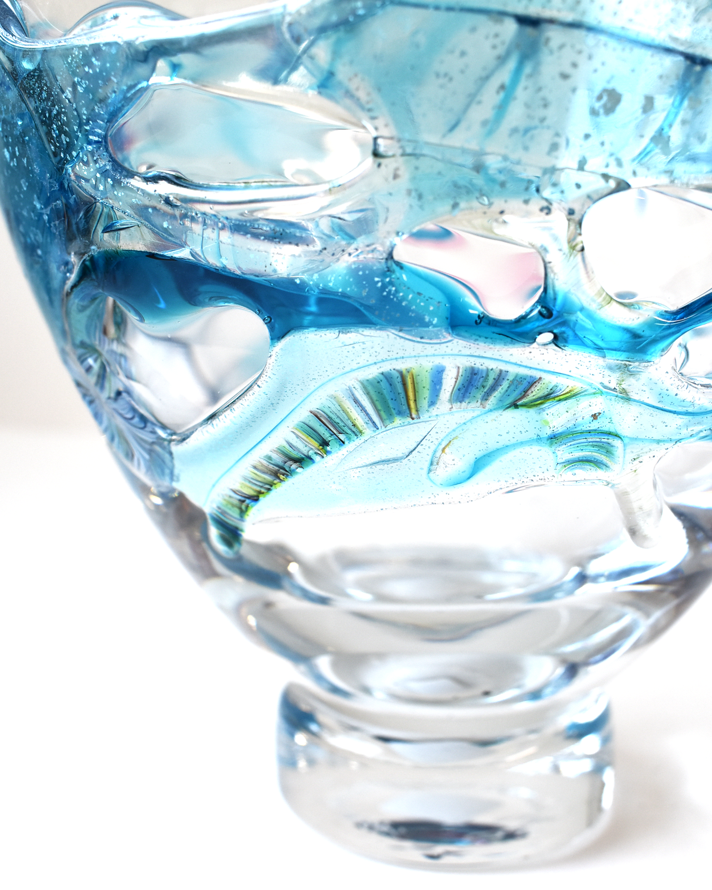 Clear glass object with blue interior on a white background