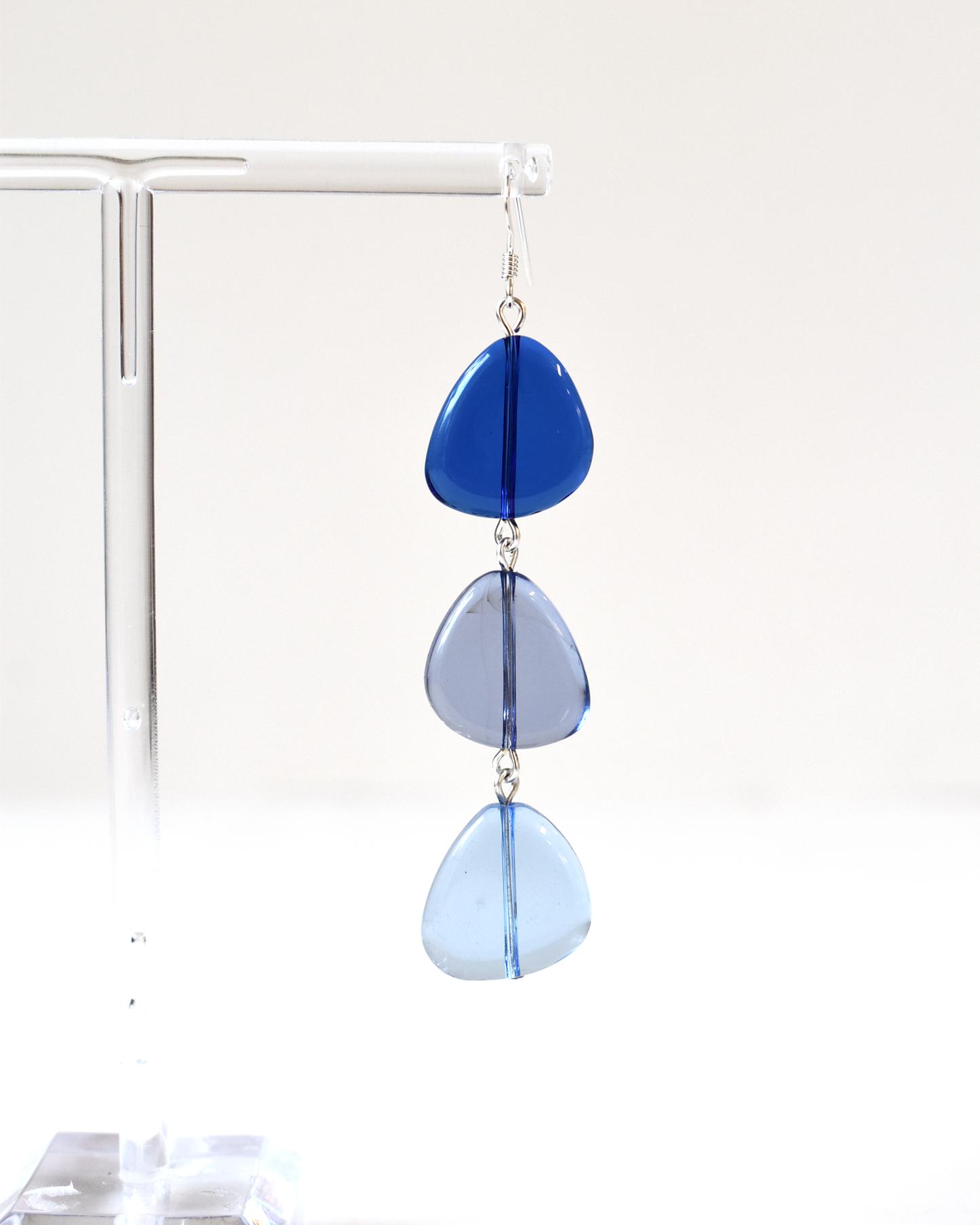Blue teardrop-shaped earrings on a white background