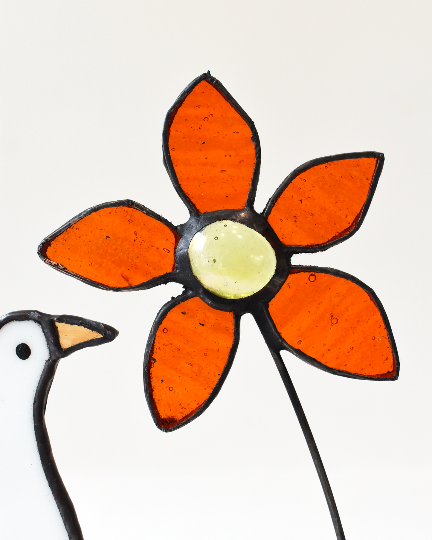 Decorative flower with orange petals and a yellow center on a white background