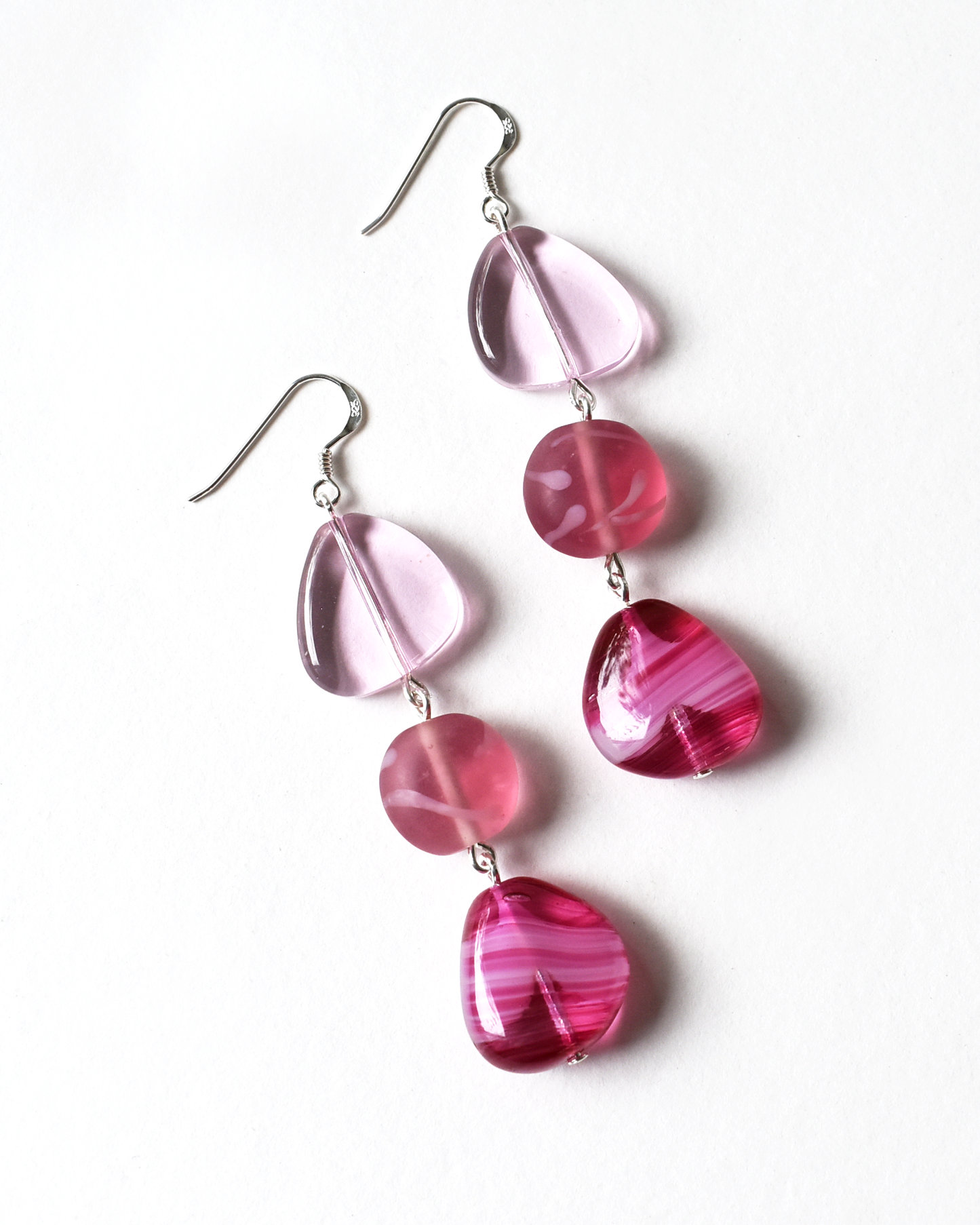 Pink and red beaded earrings on a white background