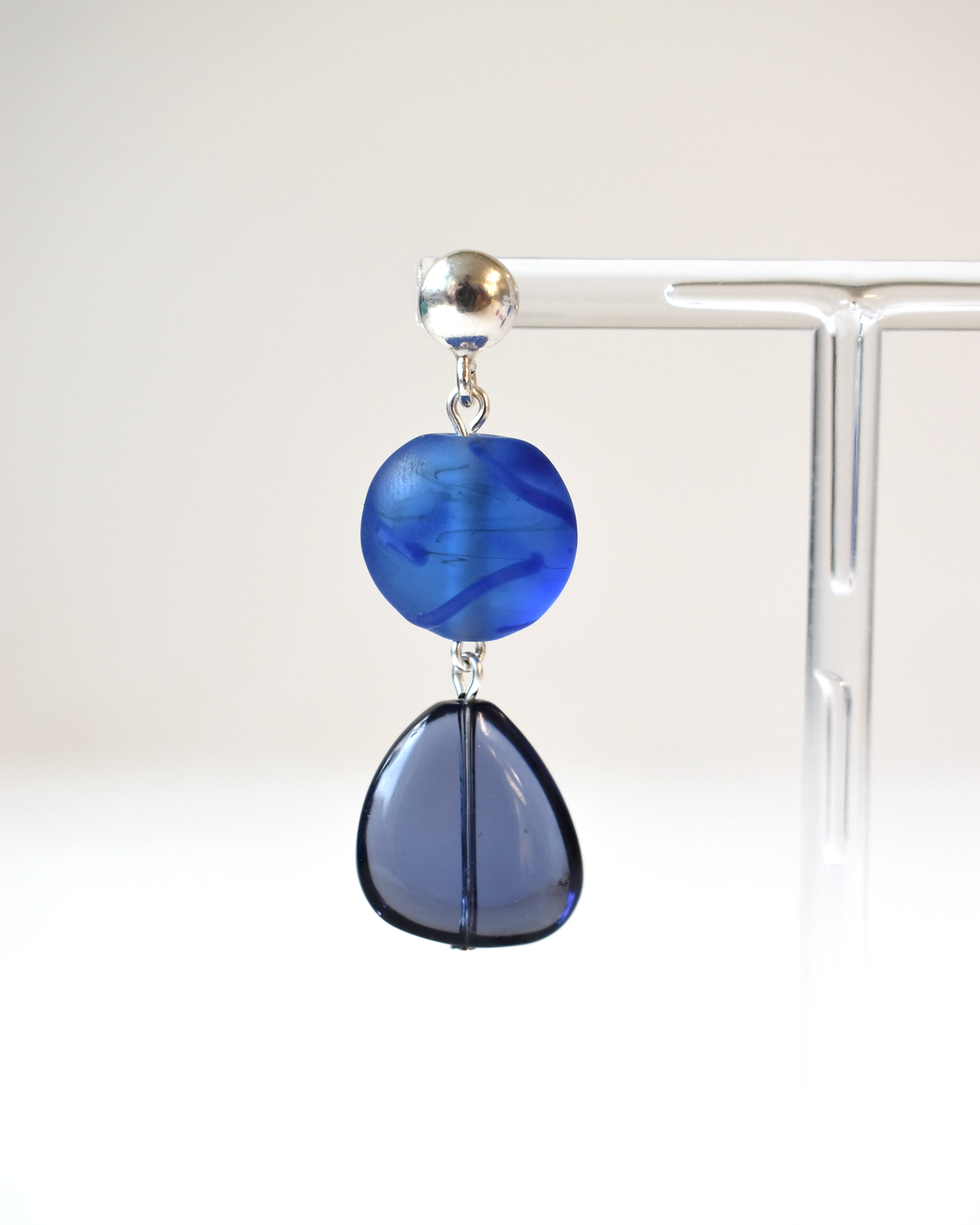Blue glass earring on a white background