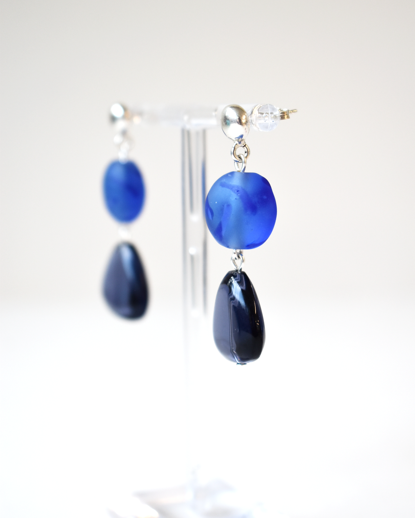 Blue teardrop earrings on a white background