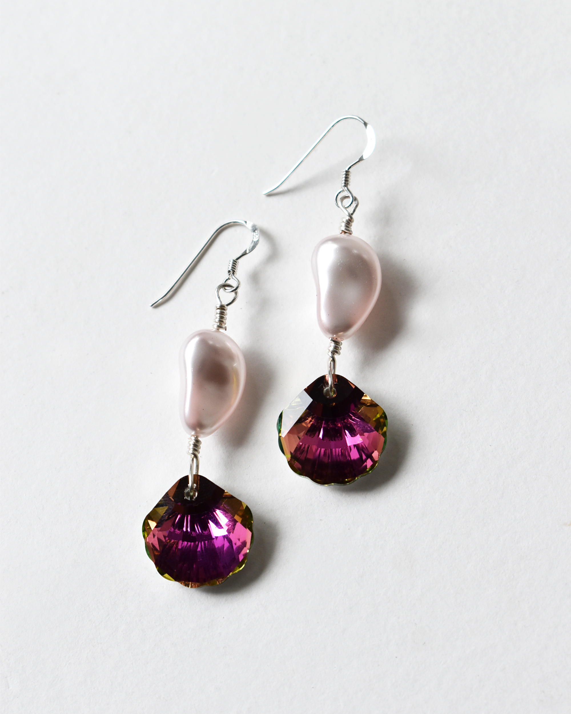 Pair of earrings with pink and purple gemstones on a white background