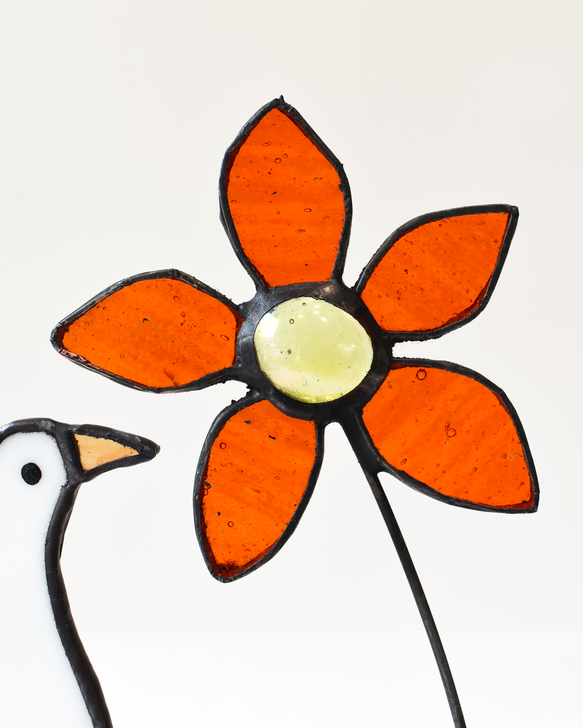 Decorative flower with orange petals and a yellow center on a white background