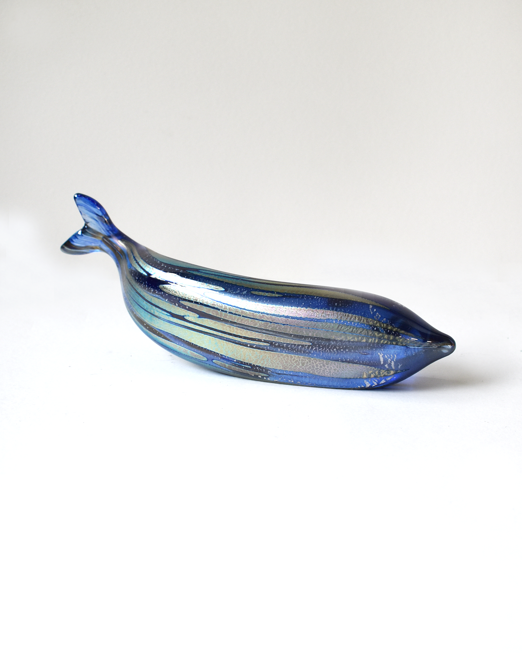 Blue glass whale-shaped object on a white background