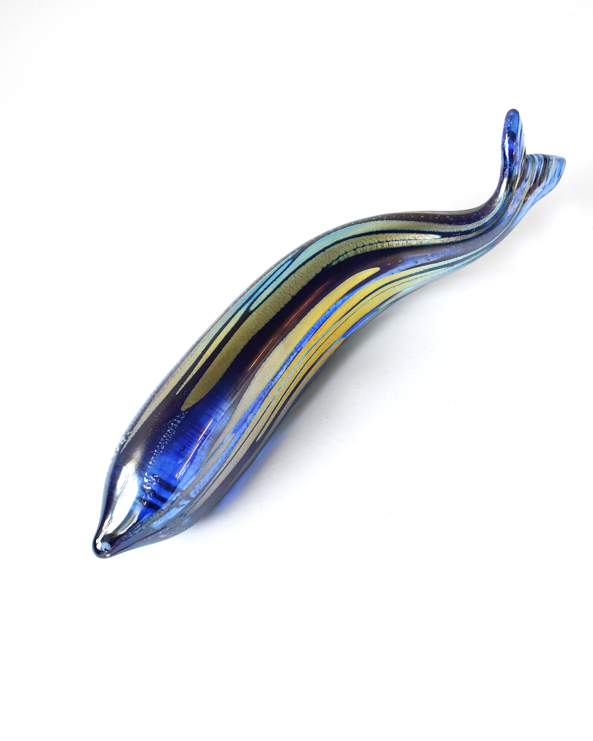 Blue and green glass fish-shaped object on a white background