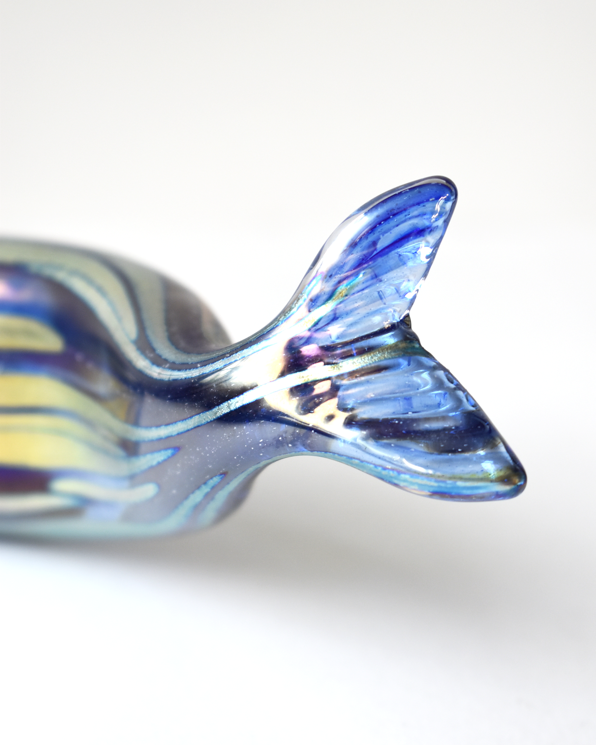 Iridescent glass fish tail on a white background