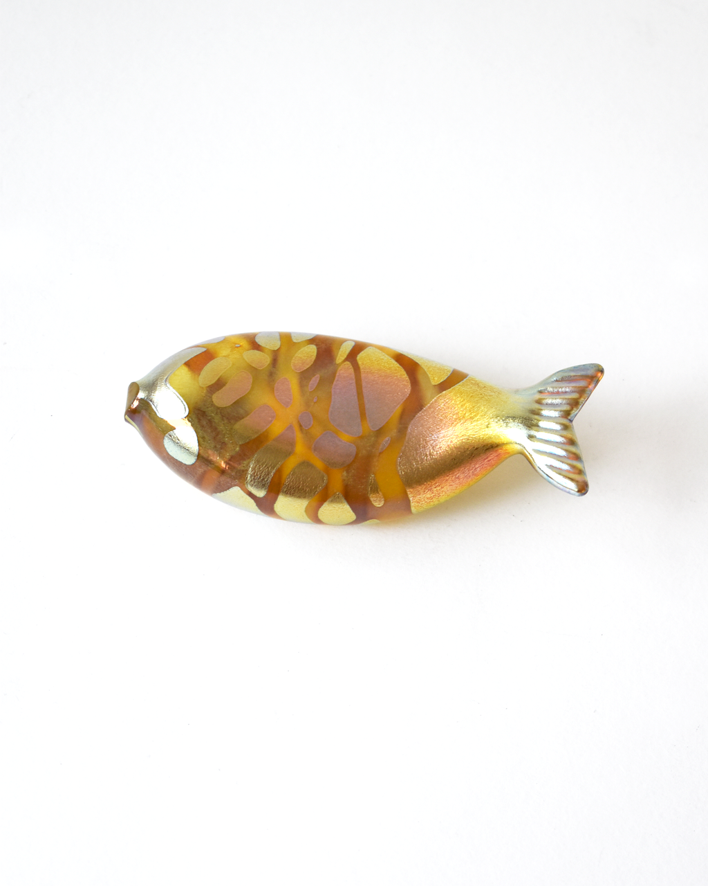 Decorative fish-shaped object with a gold and brown pattern on a white background