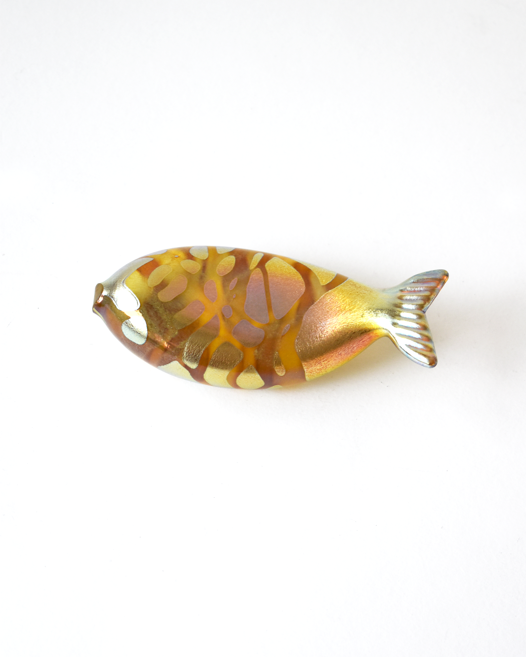 Decorative fish-shaped object with a gold and brown pattern on a white background