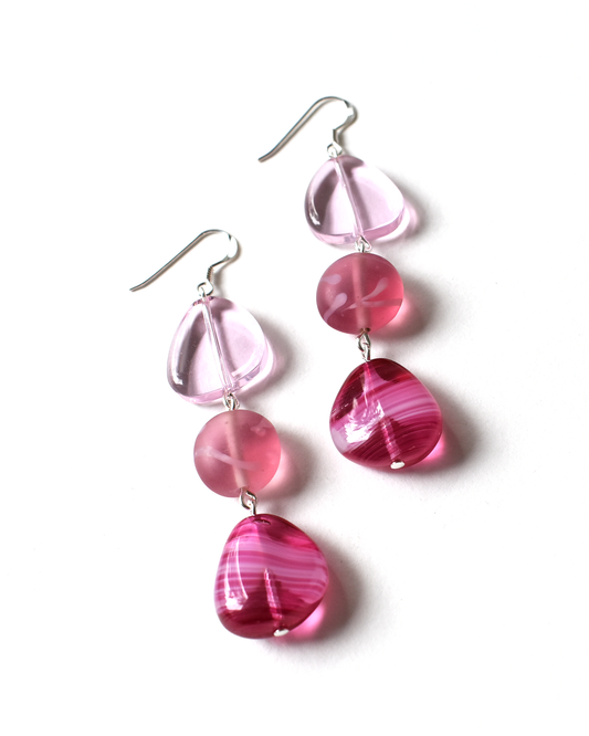 Pink and clear glass earrings on a white background