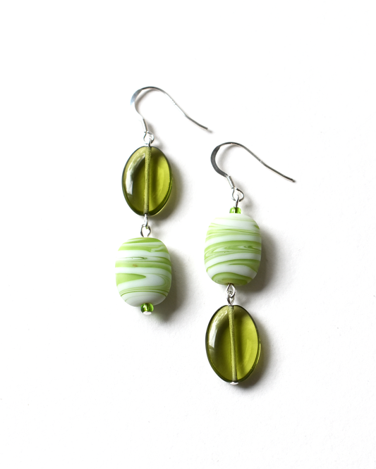 Green and white marbled earrings on a white background